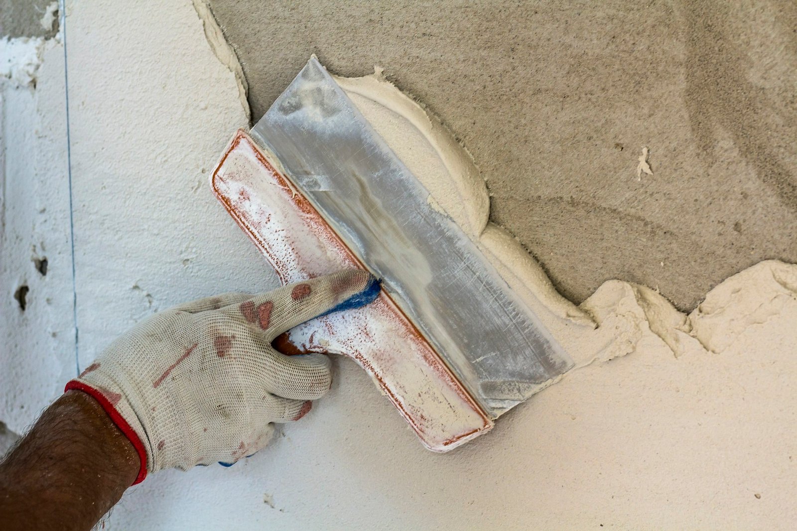 Renovation workers hand plastering the wall