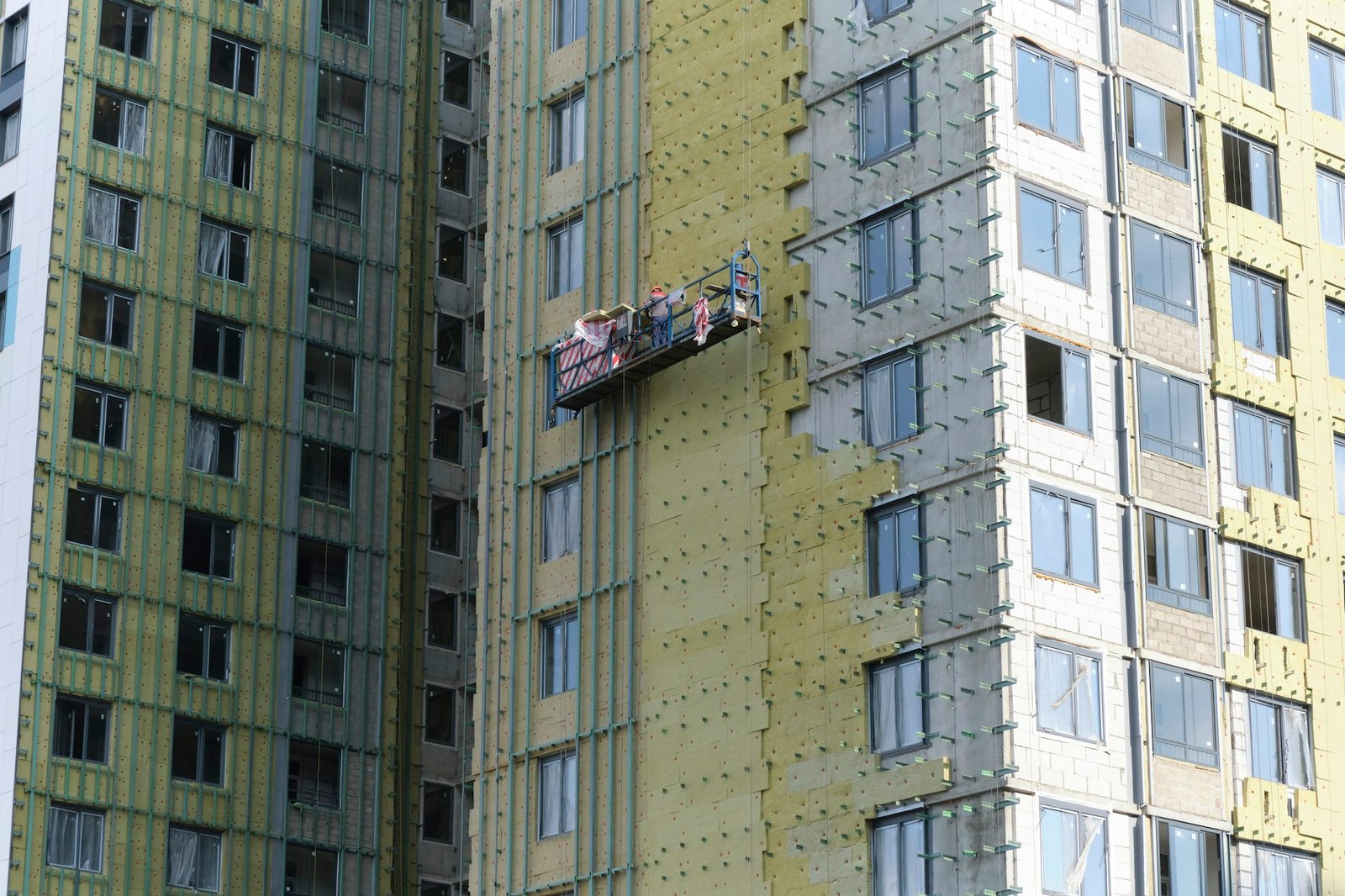 workers are insulating the wall of a building. Construction site.