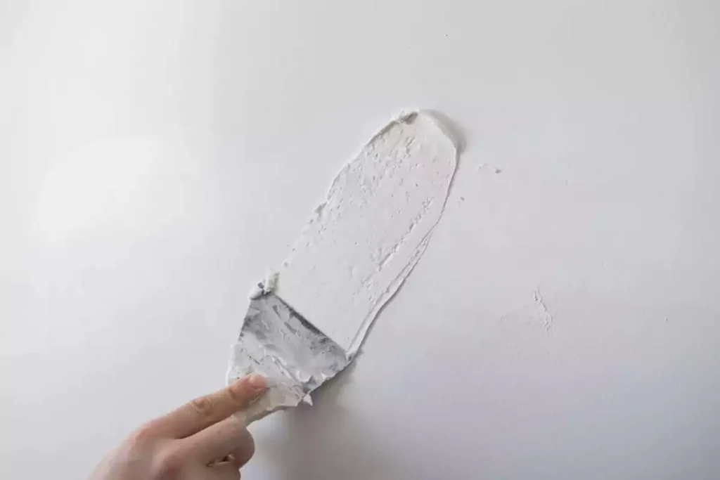 repairing walls with putty and spatula