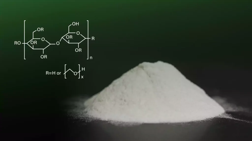 A small pile of cellulose ether powder placed on a black surface, with a chemical structure diagram of HEC next to it.