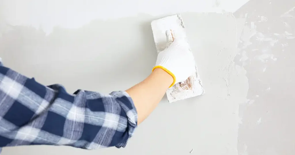 The worker is smoothing wall putty